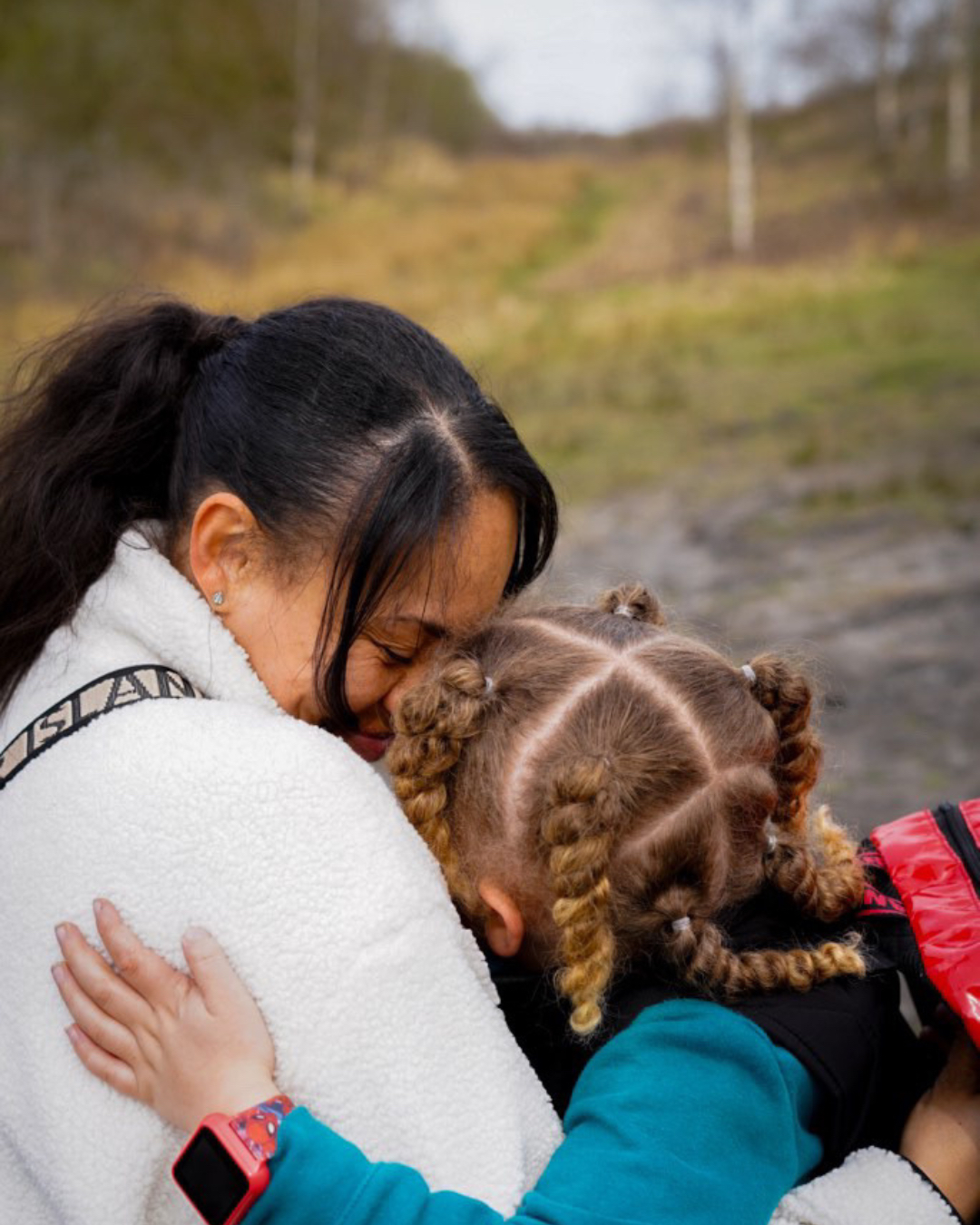 Lottie's son holding her in a close hug outdoors